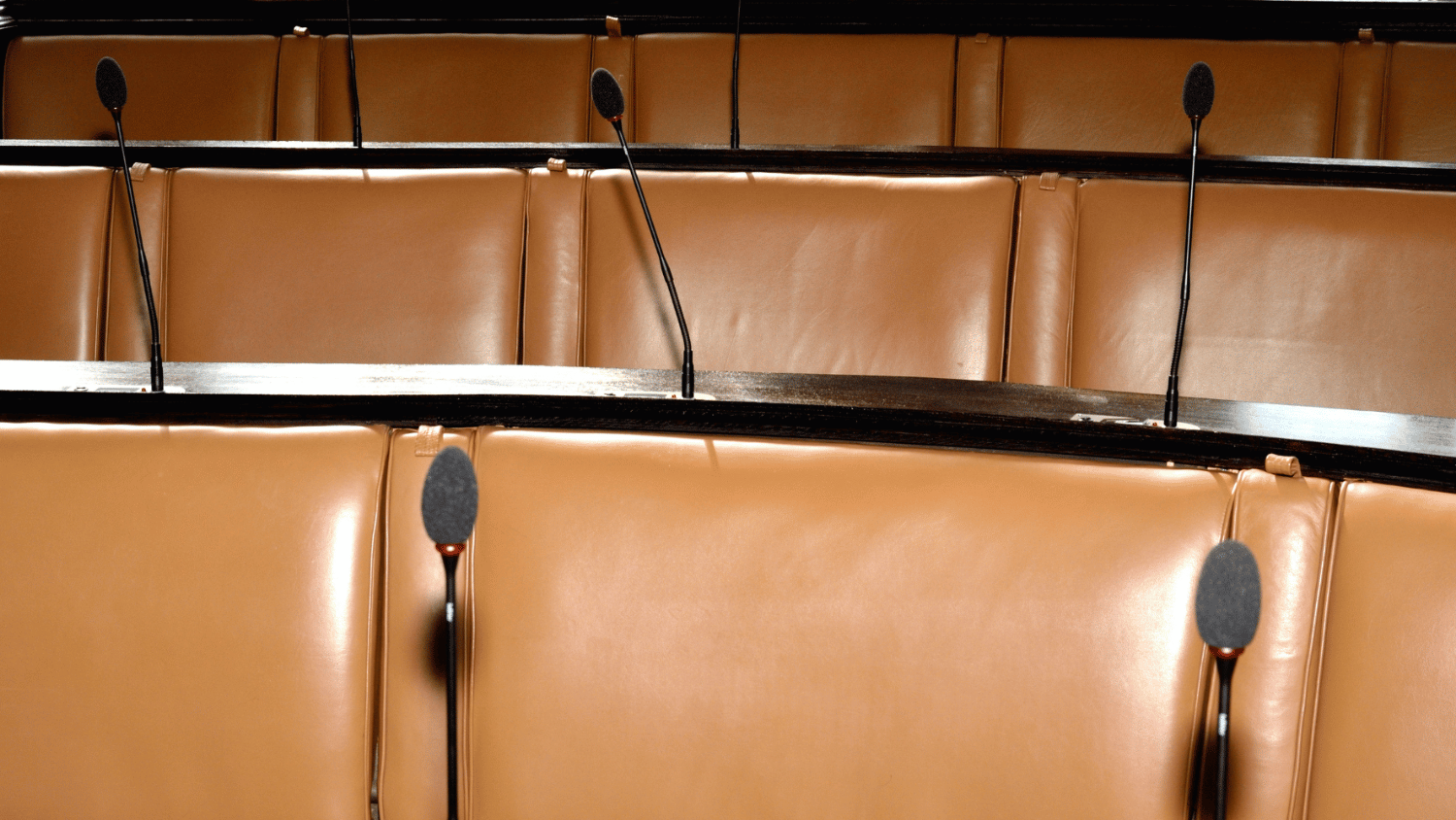 An empty room with microphones at each seat.
